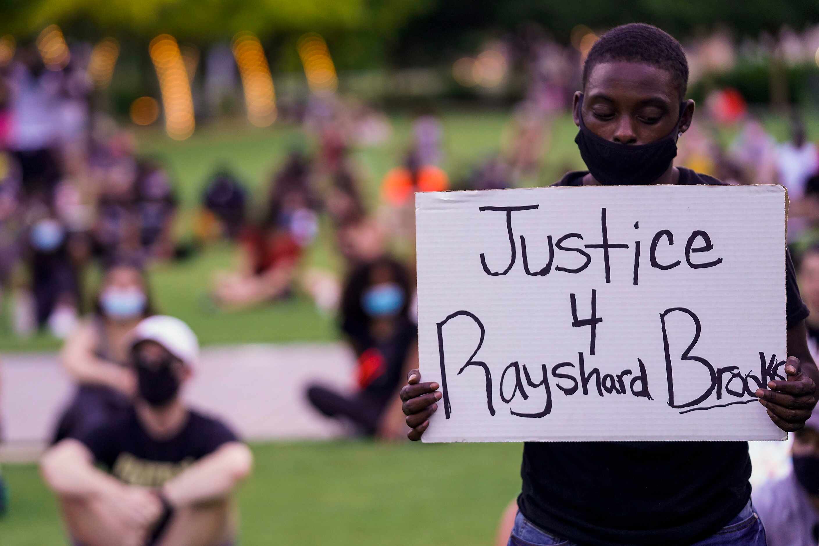 A man holds a sign calling for justice for Rayshard Brooks during rally for Juneteenth in...