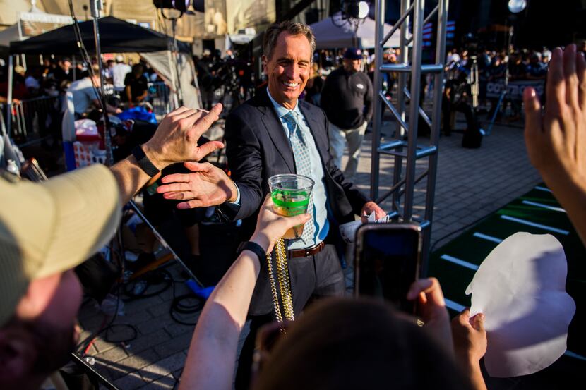Broadcaster Cris Collinsworth high-fives fans outside the stadium before an NFL game between...