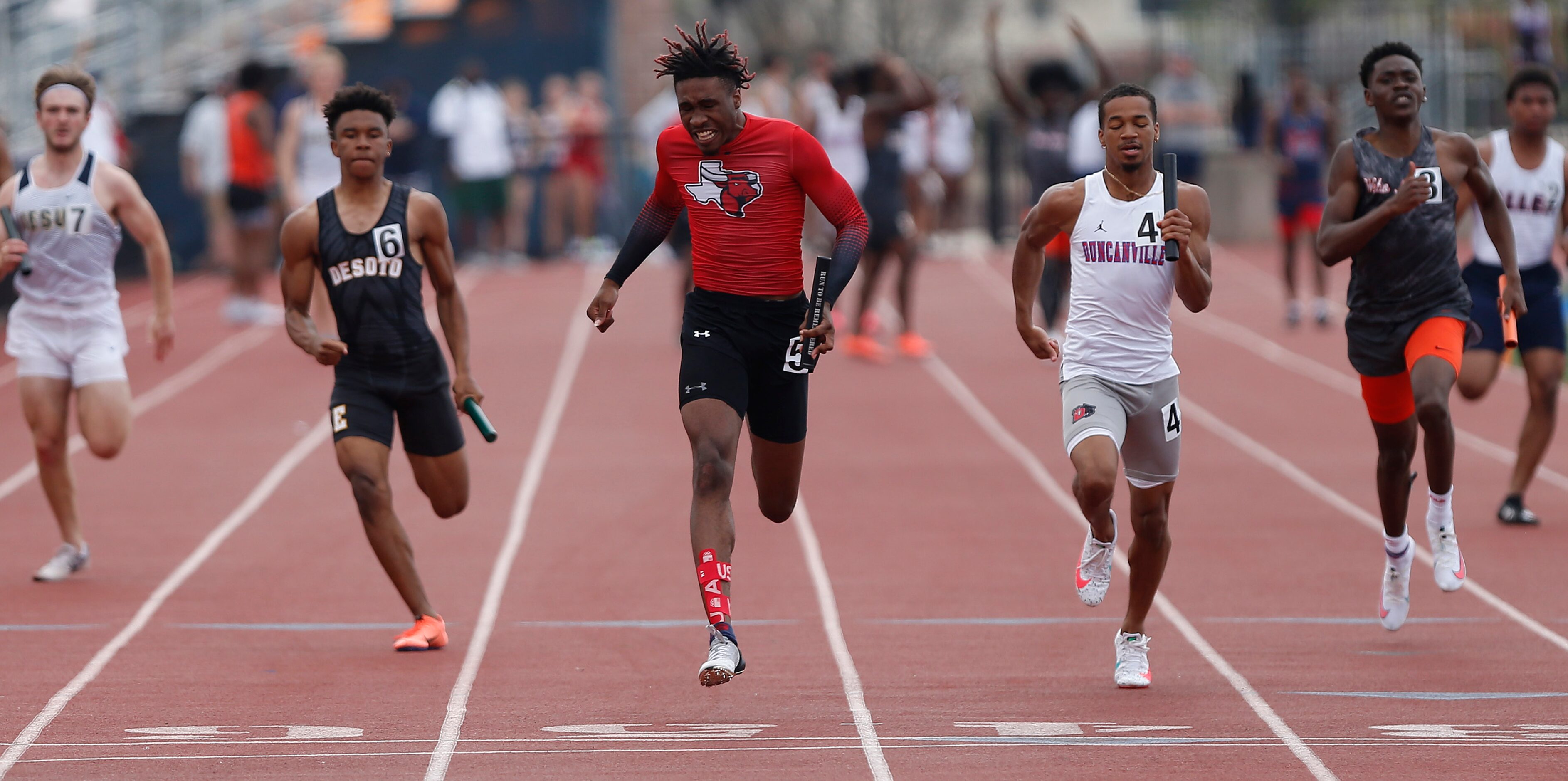 Dacorey Ware (center), 18, finishes first for Lancaster High School in the boys 4x100 during...