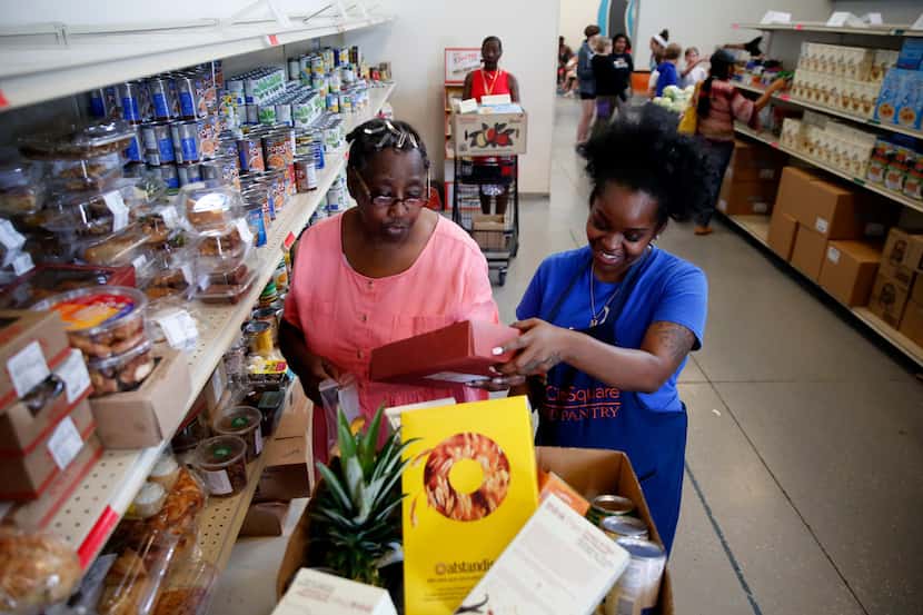 Volunteer Myree Hollins (right) helps client Ardell McNeal get groceries at the CitySquare...