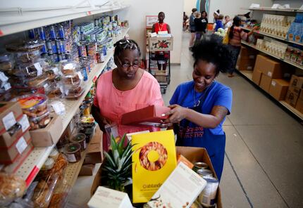Volunteer Myree Hollins (right) helps client Ardell McNeal get groceries at the CitySquare...