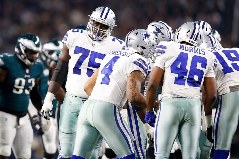 Dallas Cowboys offensive tackle Byron Bell (75) listens to the next play in the huddle in a...