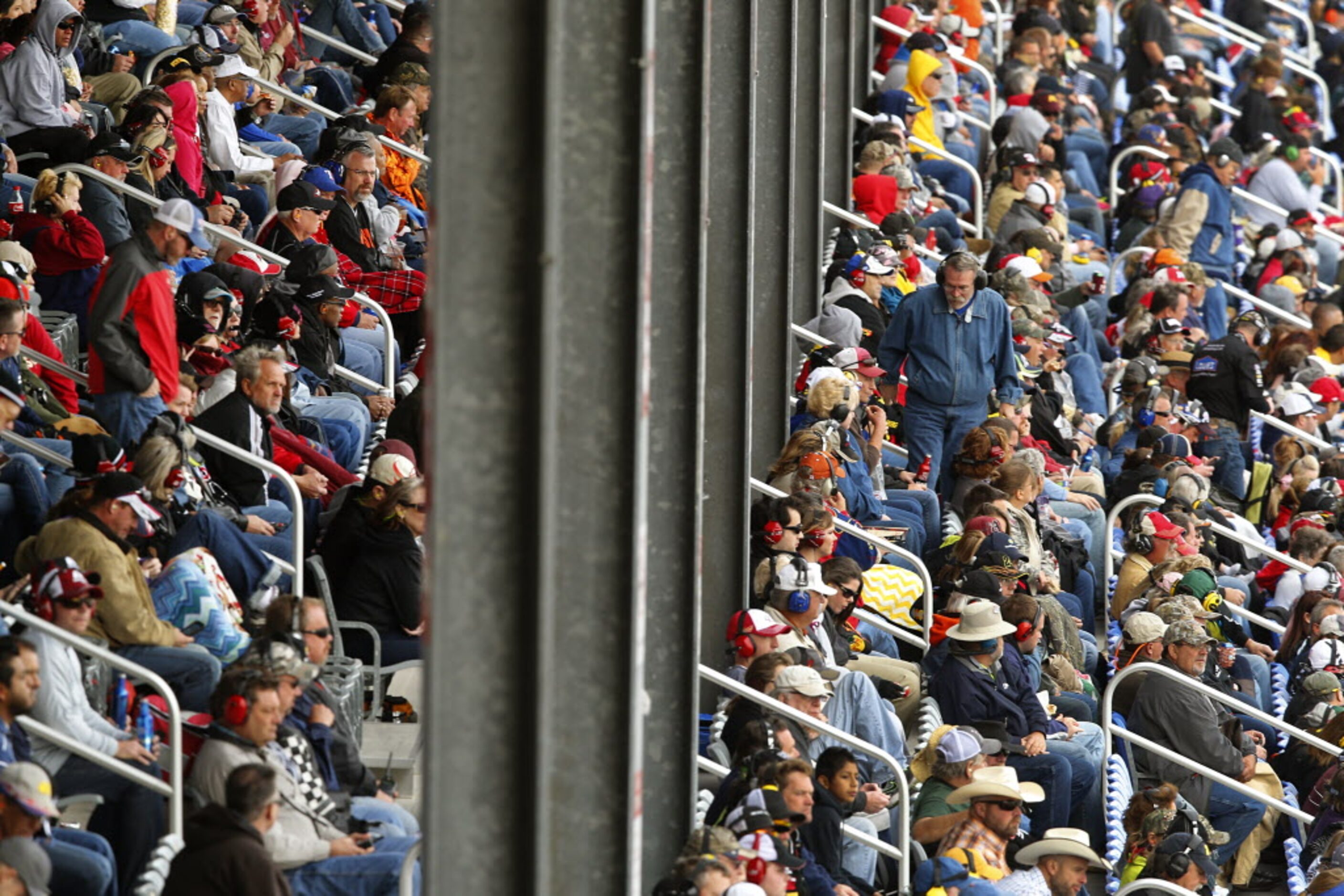 Racing fans take in the AAA Texas 500 action in the grandstand at the Texas Motor Speedway...