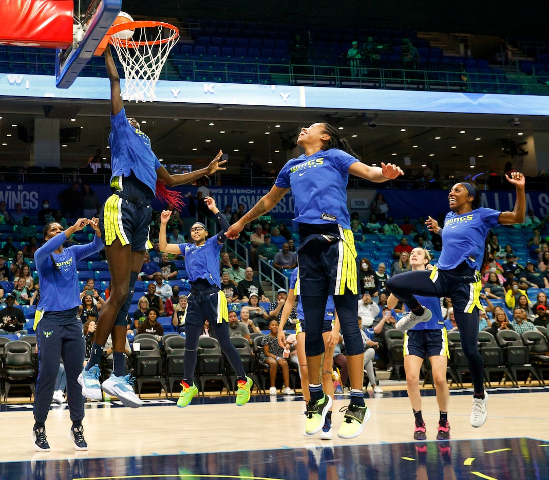 Dallas Wings center Awak Kuier (28) dunks the ball as part of a team ritual before a game...