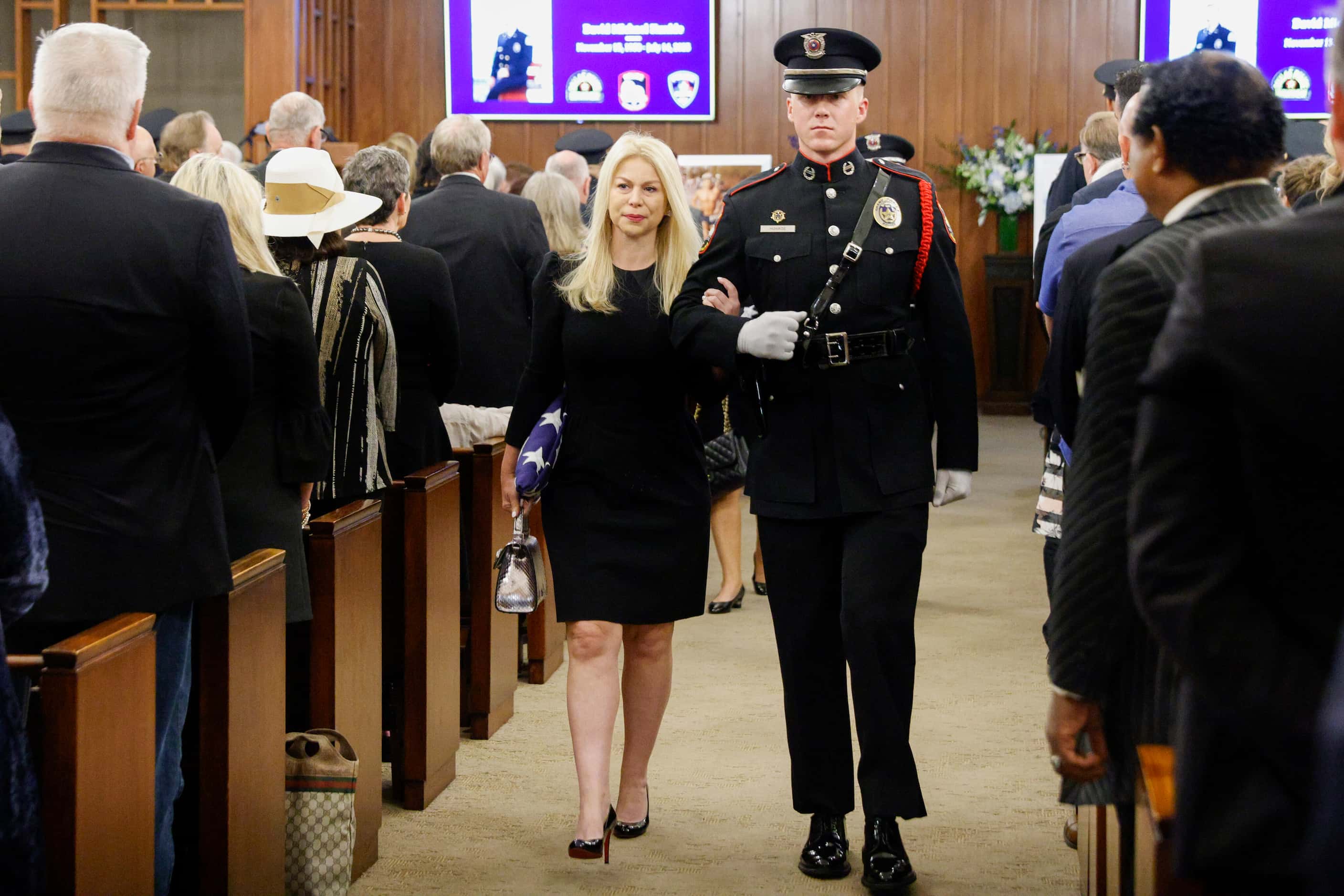 Sarah Dodd, David Kunkle’s wife, is escorted by a Grand Prairie police honor guard officer...