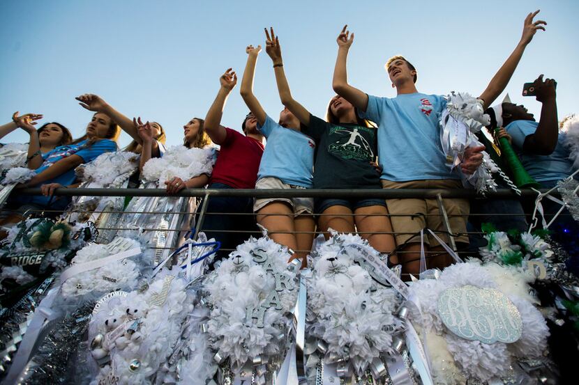 Mansfield Lake Ridge students sing their school song above homecoming mums before a high...