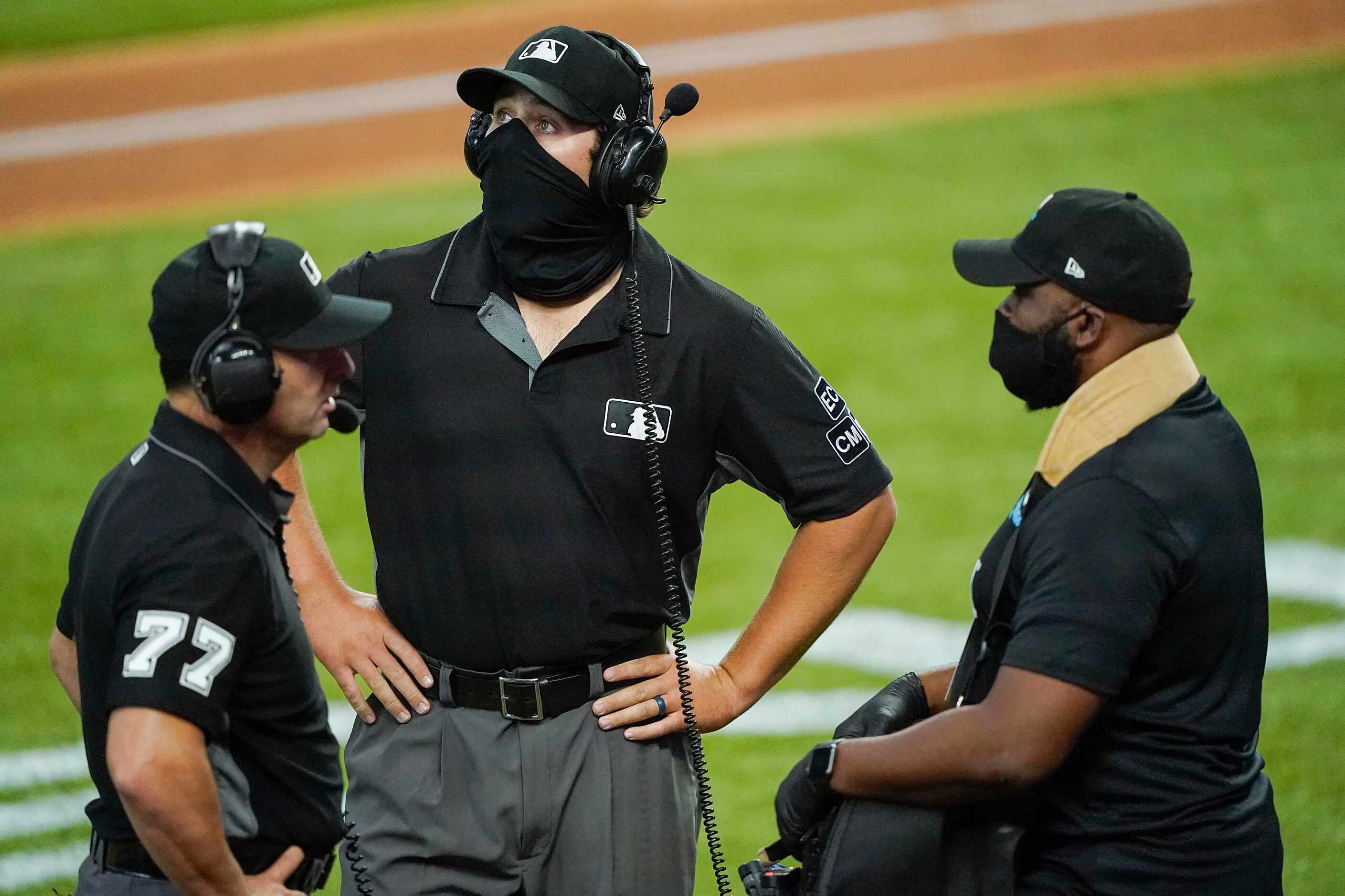 Umpires John Libka (facing) and Jim Reynolds wait for the results of a video review after...