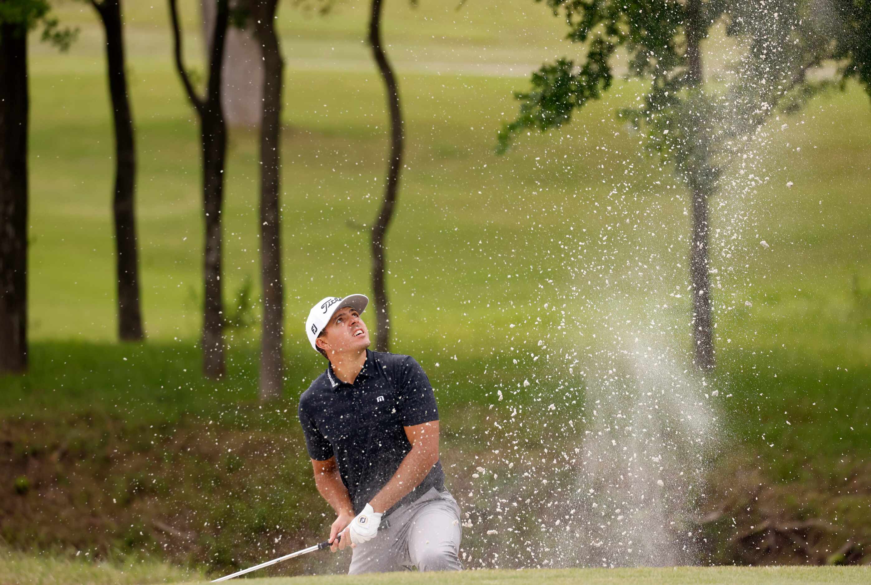 Joseph Bramlett watches his ball after hitting out of a bunker on the 7th hole during round...