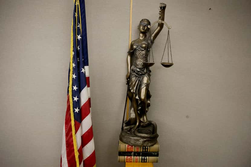 Stock art of a statue of Lady Justice in a courtroom in the Frank Crowley Courts Building in...