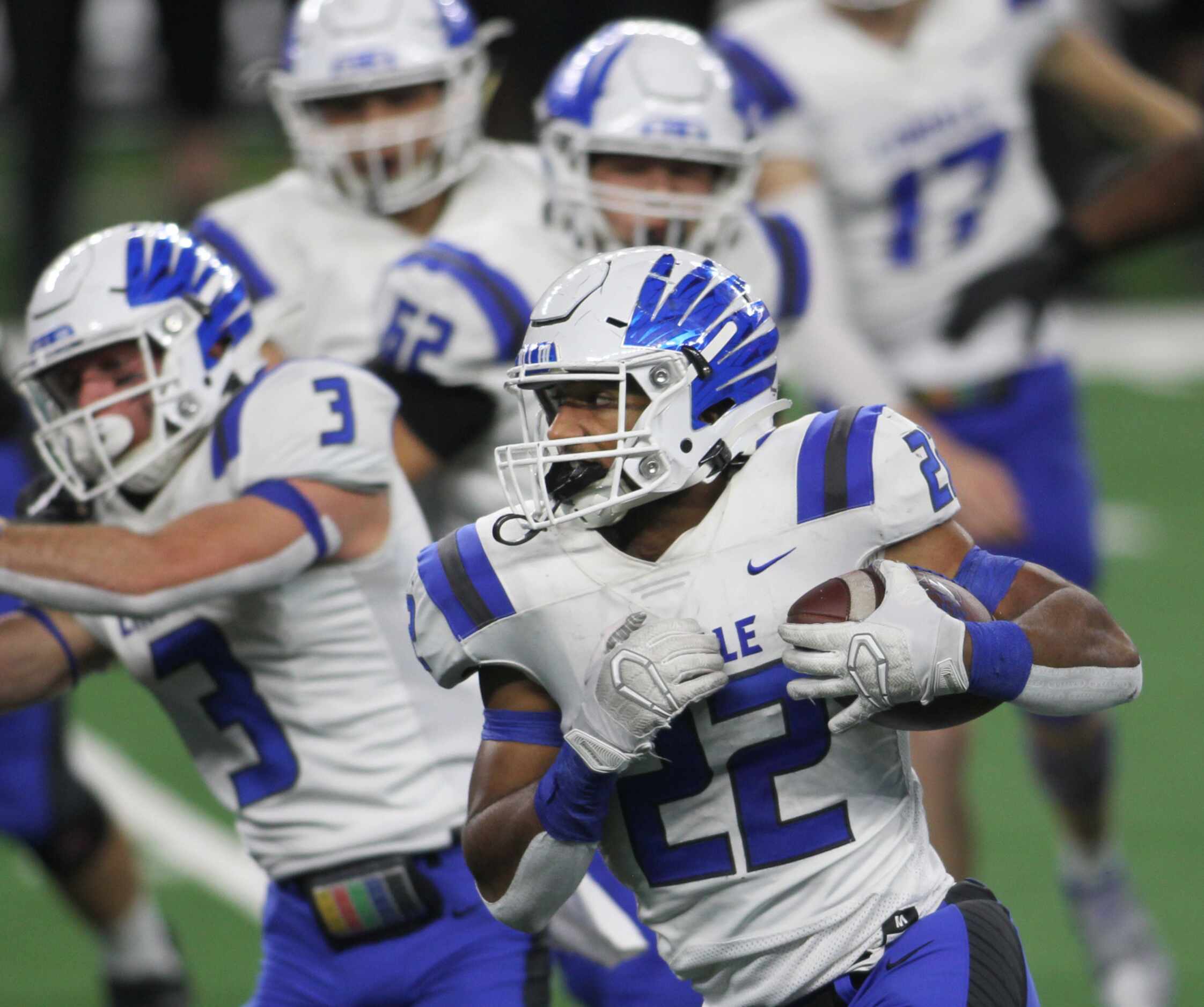 Lindale running back Jordan Jenkins (22) runs in front of a host of blockers during first...