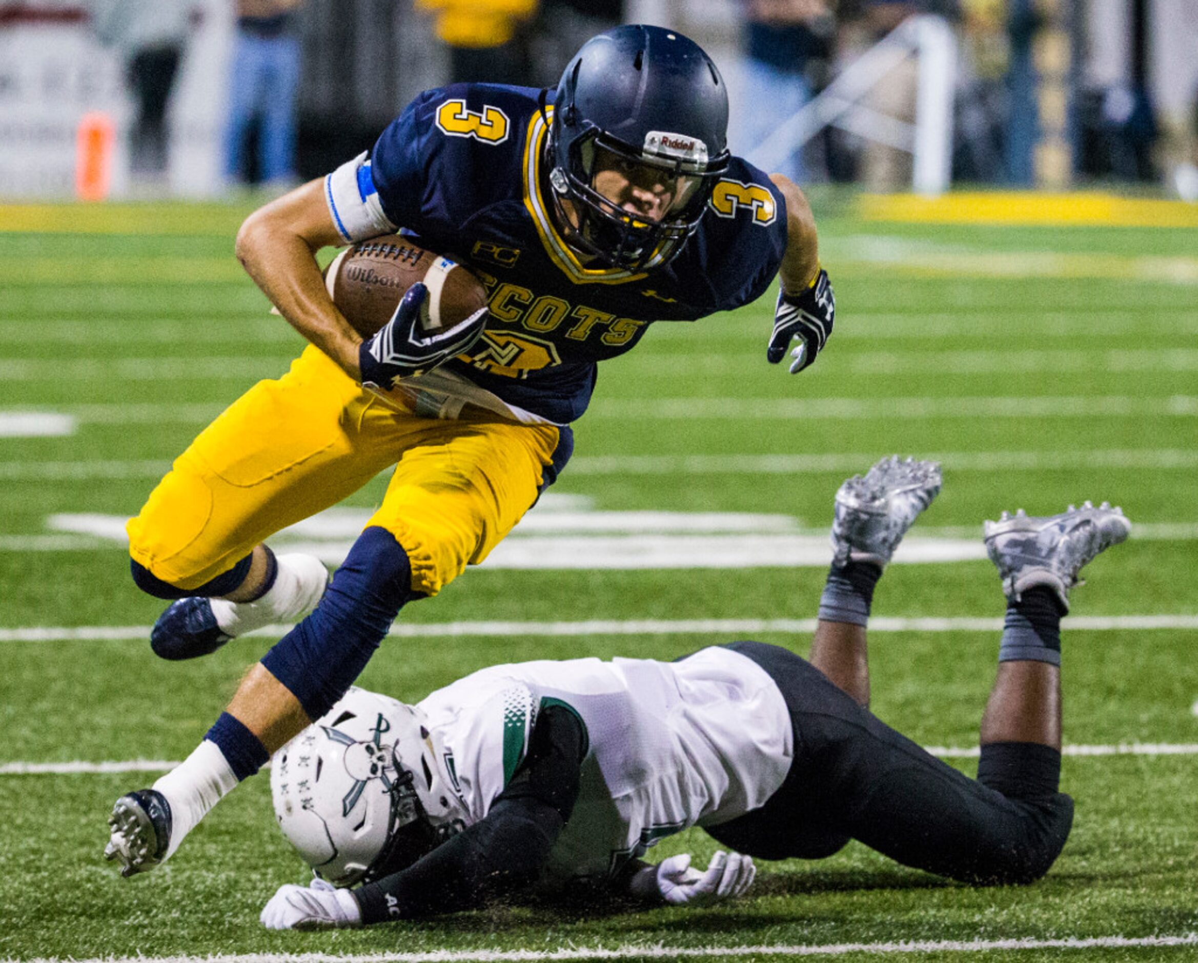 Highland Park wide receiver J.T. Dooley (3) narrowly escapes a tackle by Mesquite Poteet...