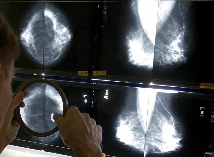 In this May 6, 2010 file photo, a radiologist uses a magnifying glass to check mammograms...