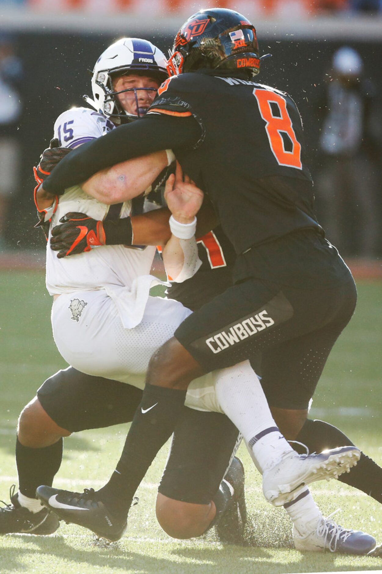 TCU quarterback Max Duggan (15) is brought down by Oklahoma State cornerback Rodarius...