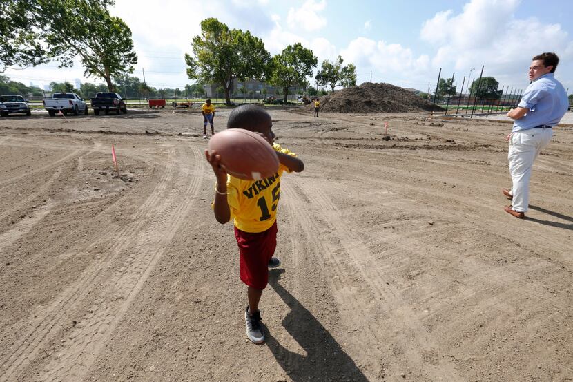 Marcus Neal, 7, in the #15 jersey with the  West Dallas Vikings, prepares to through the...