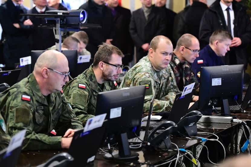 Soldiers of different nations work together in the 'Main Command Post' (MCP) during a visit...
