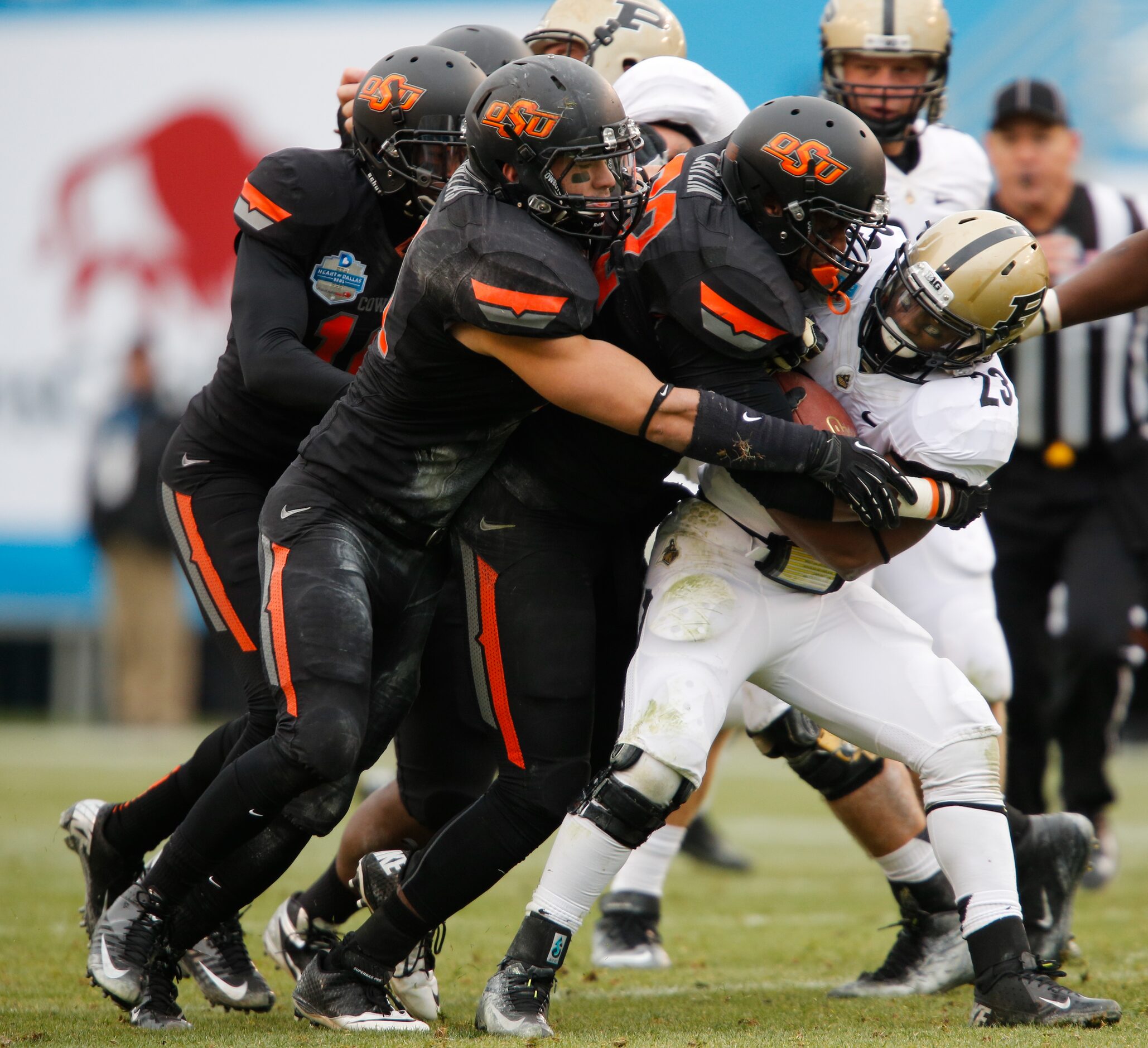 Purdue's Ralph Bolden (23) is tackled by a gang of Oklahoma State Cowboys during the...