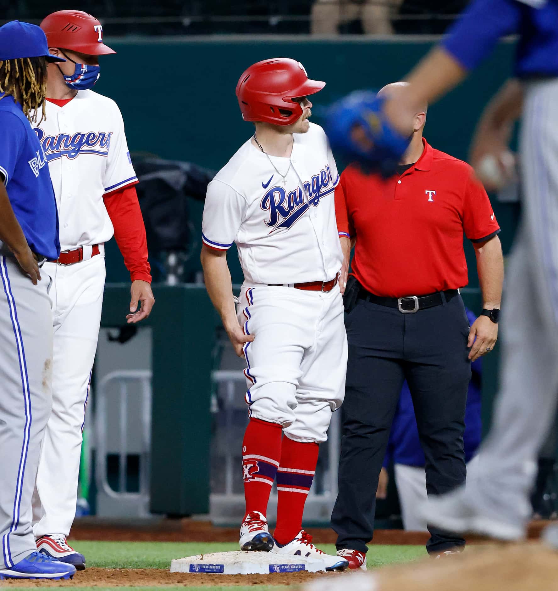 Texas Rangers batter Brock Holt (16) grabs his left leg as he singled during eighth inning...