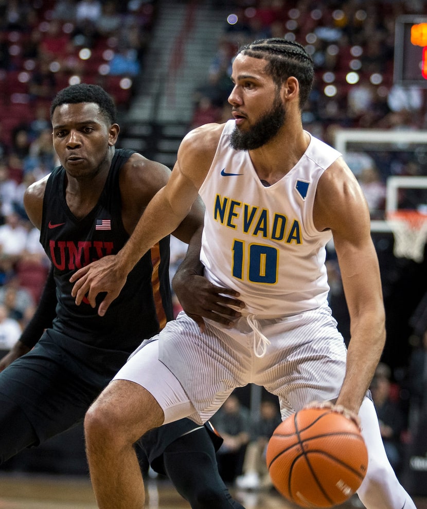 Nevada forward Caleb Martin (10) drives the lane on UNLV guard Amauri Hardy (3) during the...