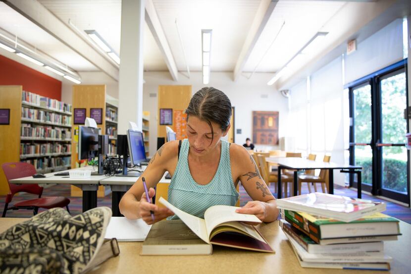 Cat Hahn of Denton flips through a book at the Emily Fowler Central Library, where late...