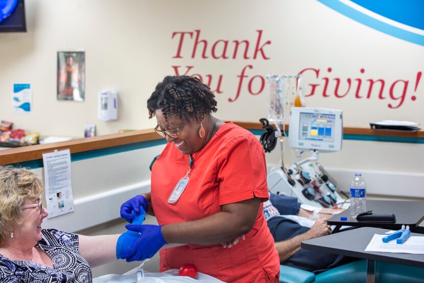 Donor Center supervisor Nicole Taylor (center) as she prepares to draw blood at the Carter...