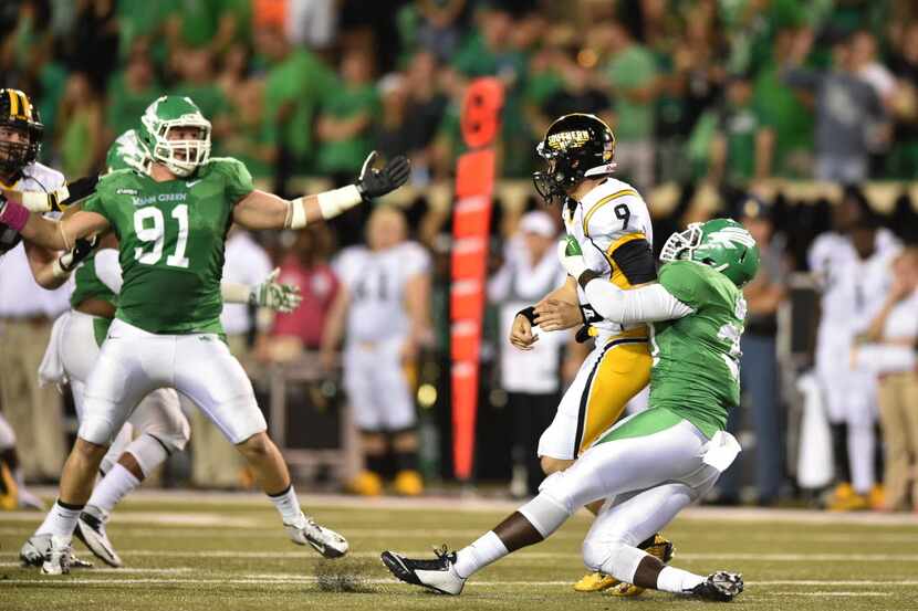 North Texas defensive end Jarrian Roberts drags down Southern Miss quarterback Nick Mullens...