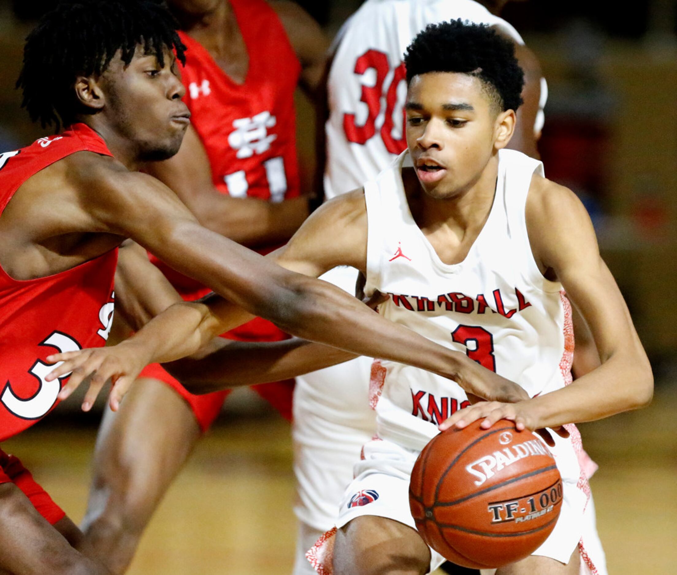 Kimball High School guard D.J. Pigford (3) is defended by Cedar Hill High School center...