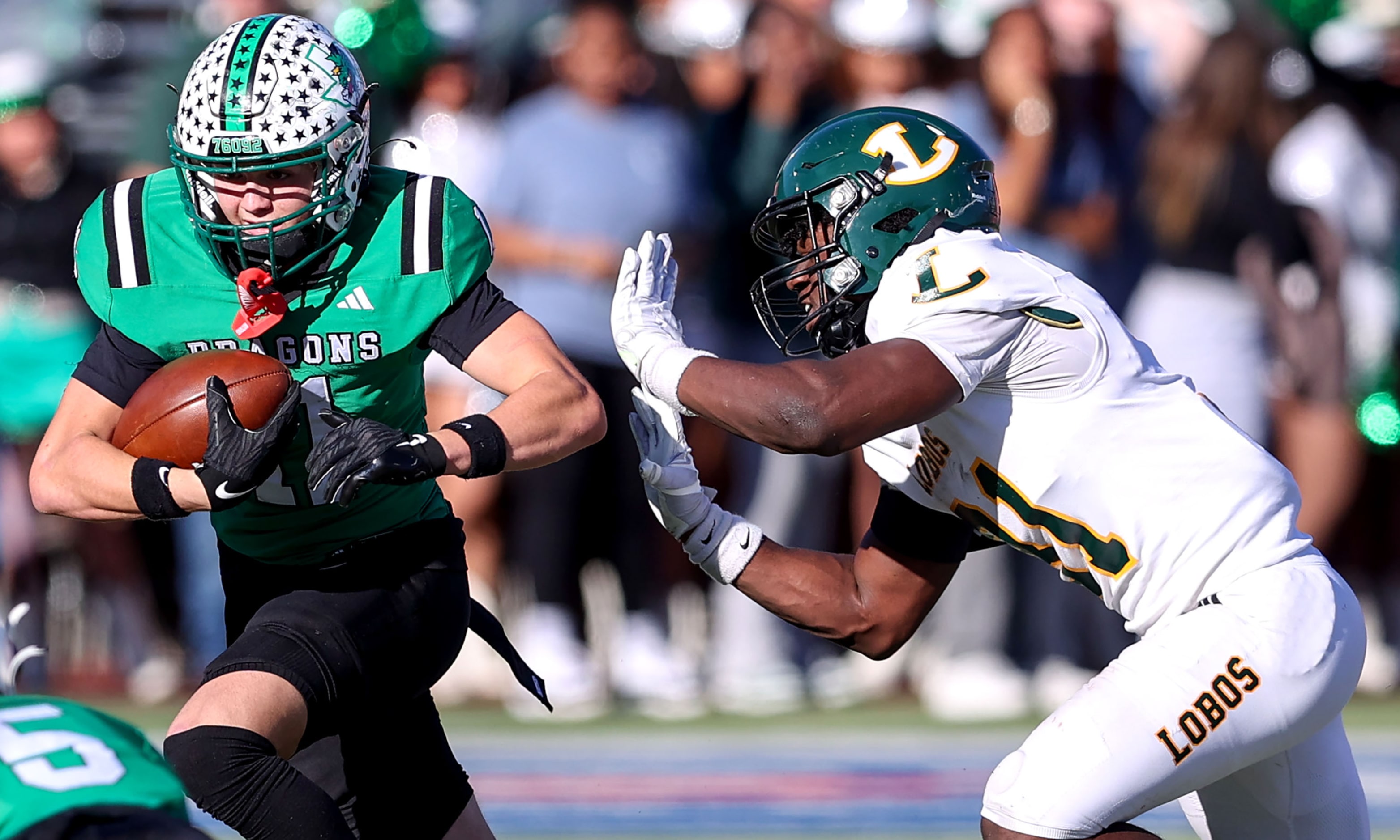 Southlake Carroll wide receiver Brock Boyd (left) gets pushed out of bounds by Longview...