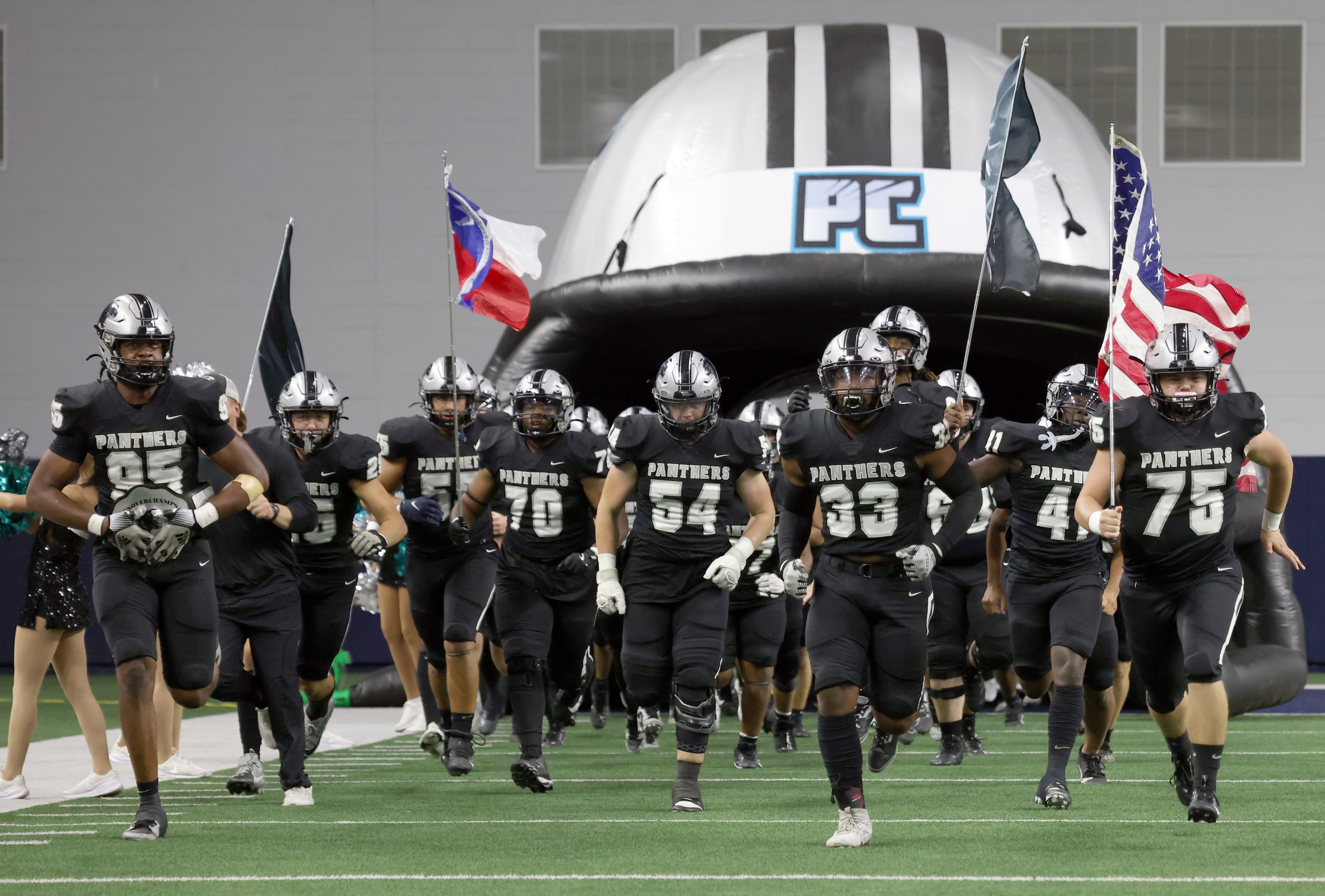 Frisco Panther Creek players run from the team's inflatable helmet onto the field prior to...