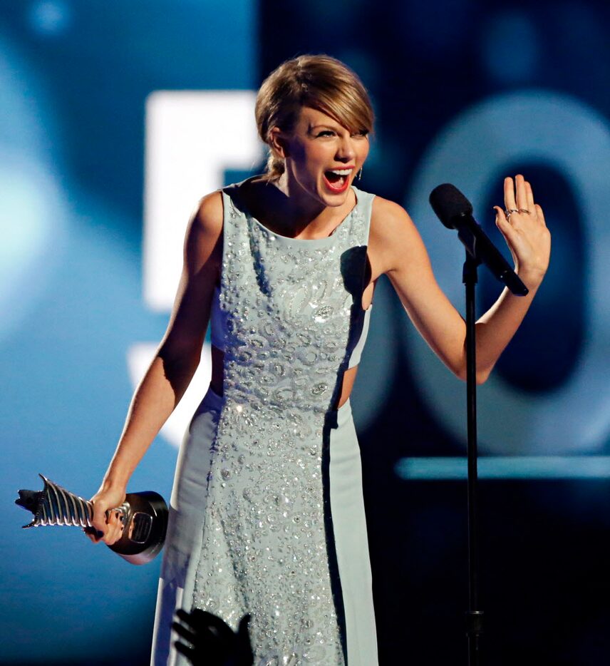 Taylor Swift reacts after receiving her Milestone Award during the 2015 Academy of Country...