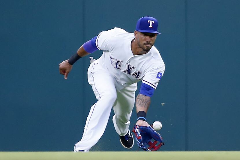 Texas Rangers center fielder Ian Desmond catches a fly ball hit by Kansas City Royals during...