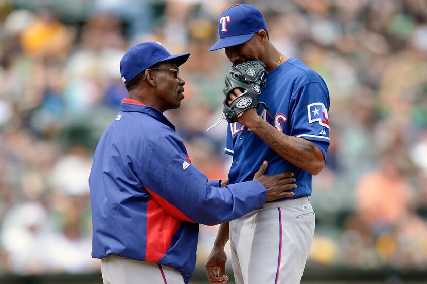 Manager Ron Washington of the Texas Rangers comes out to the mound to talk with pitcher...