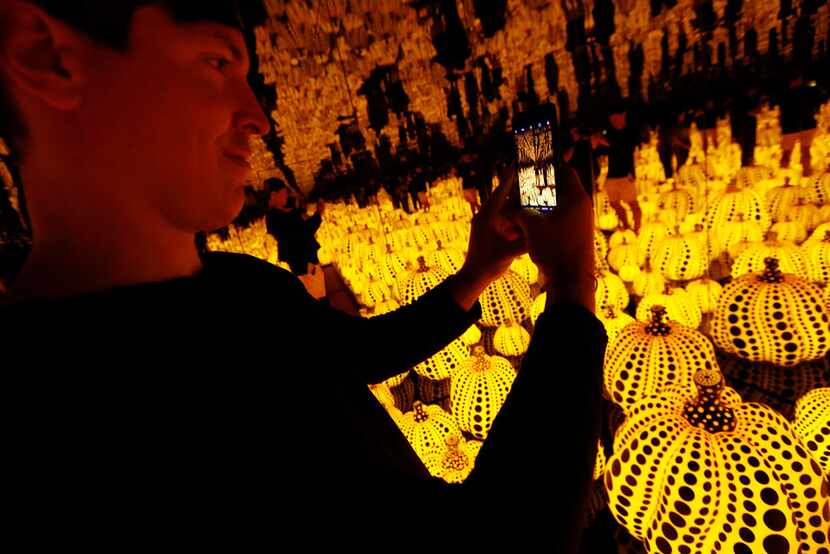 Todd Joyce takes photos in the Yayoi Kusama installation 'All the Eternal Love I Have for...