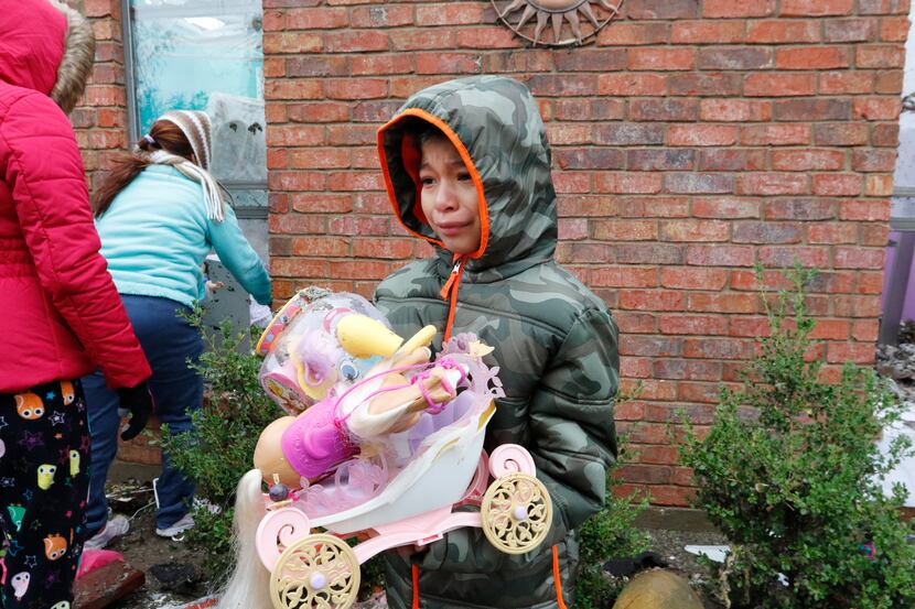 Hitel Rodriguez, 8, carries toys from his uncle's home in the 300 block of Mesa Drive in...