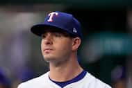 Texas Rangers starting pitcher Cody Bradford walks in the team's dugout in the first inning...