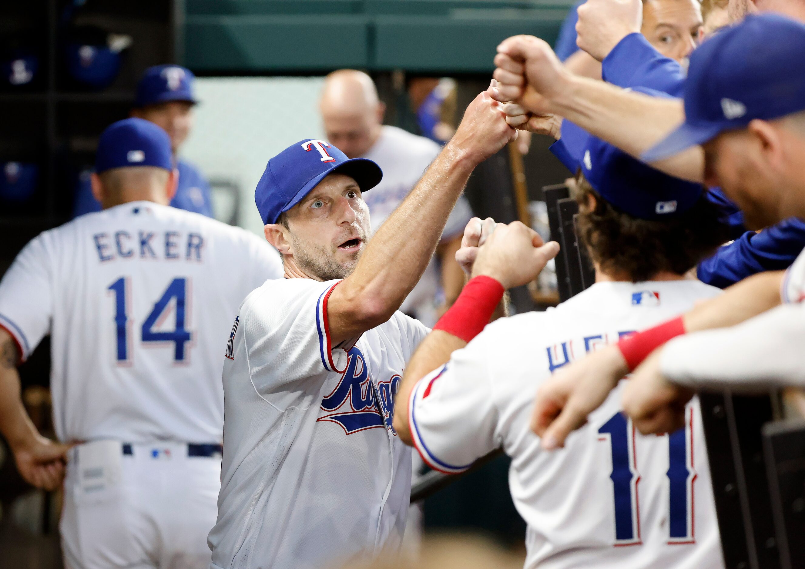 Texas Rangers starting pitcher Max Scherzer (31) delivers fist bumps to all his new...