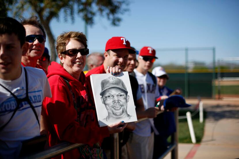  Texas Rangers fan Connie Goodwin, of Carrollton, Texas, holds up a drawing she made of...