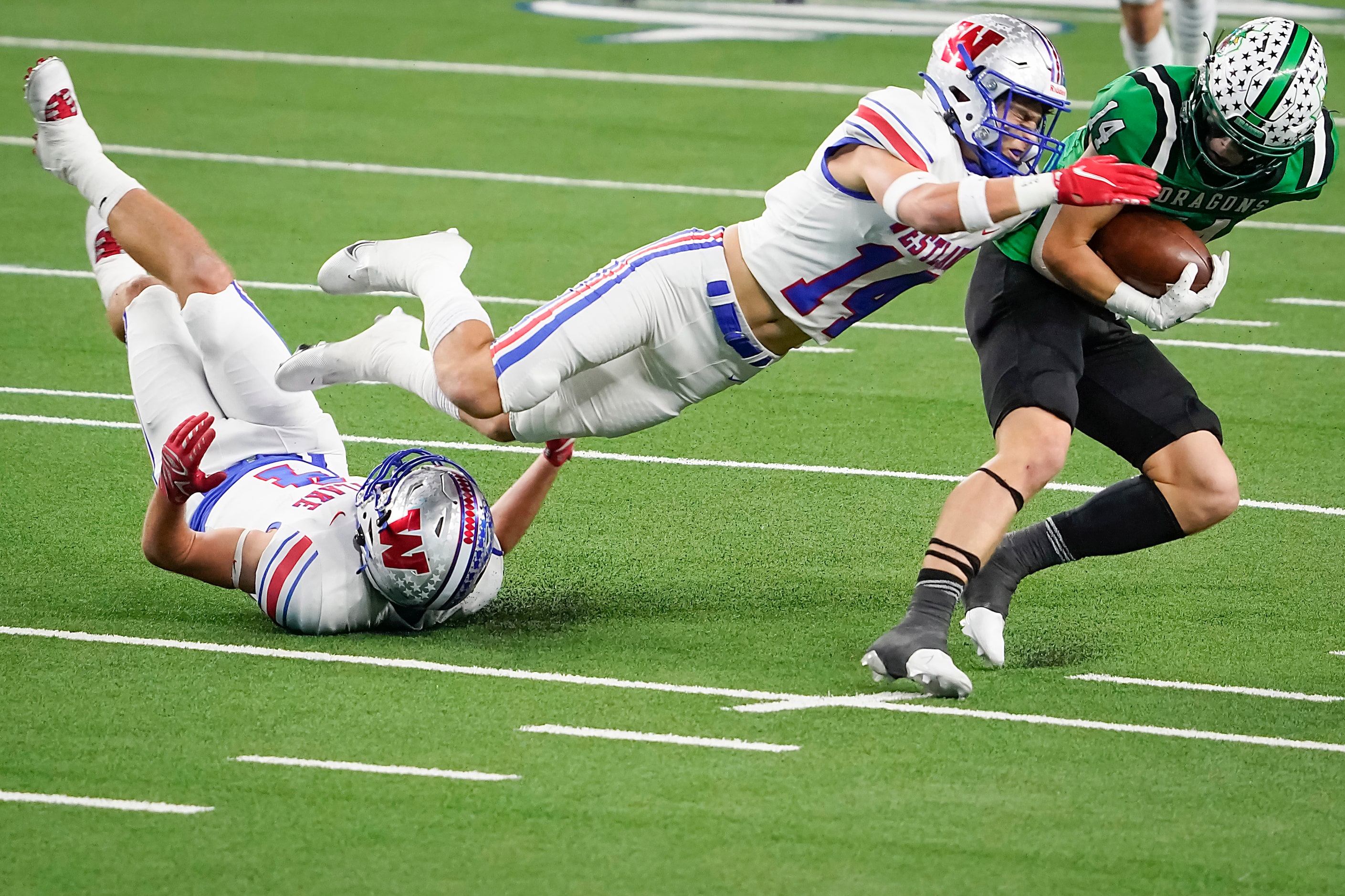 Southlake Carroll wide receiver Brady Boyd (14) breaks the tackles of both Austin Westlake...