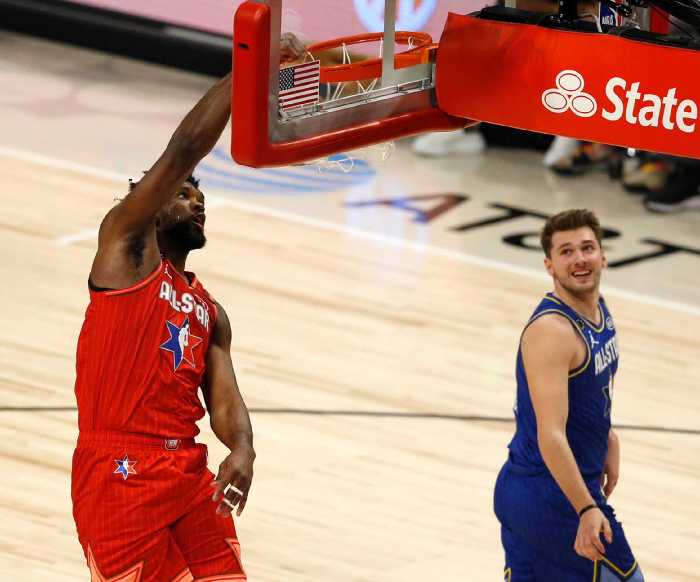 Team Giannis' Joel Embiid (24) dunks as Team LeBron's Luka Doncic (2) watches during the...