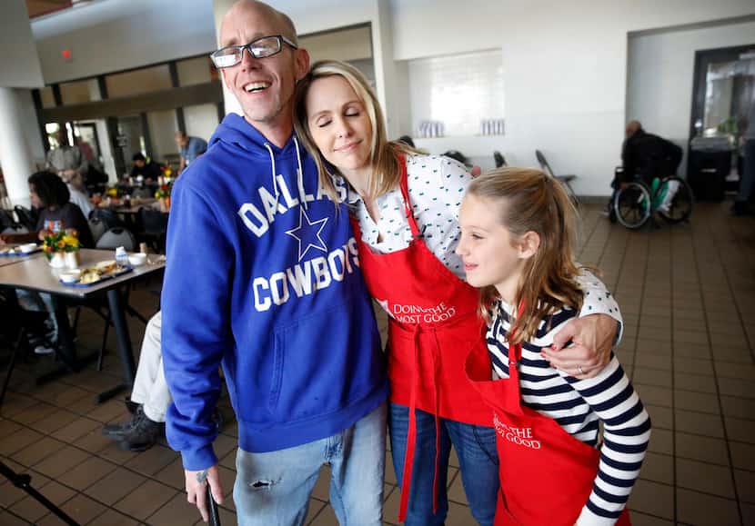 Meredith Land gives Reid Holiday, who is hearing impaired, a hug after serving lunch with...