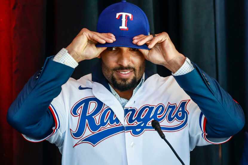 Marcus Semien adjusts his Texas Rangers baseball hat at a news conference at Globe Life Park...