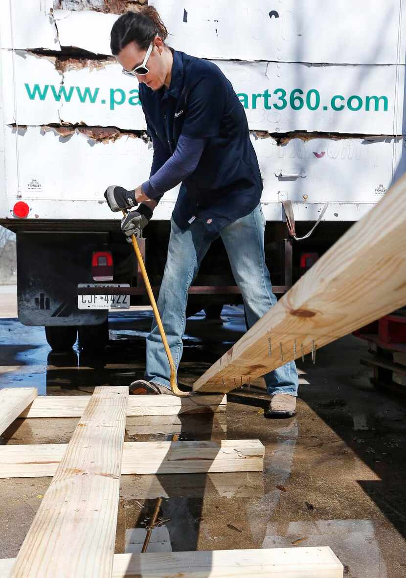 
Jason Whorton uses a pry-bar to breakdown a wood pallet at PalletSmart workshop in Fort...