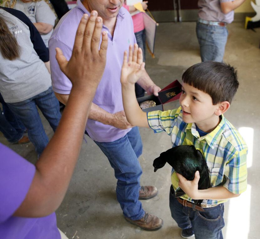 Carson Stegall, 9, got a high-five from friend Keylan Warren, 16, on Sunday after taking...
