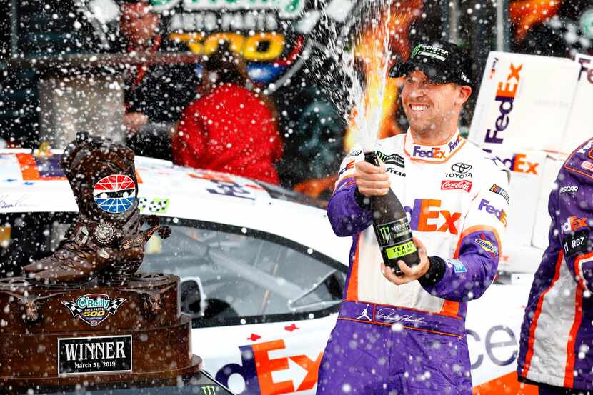 NASCAR driver Denny Hamlin of the No. 11 FedEx Office Toyota celebrates with champagne in...