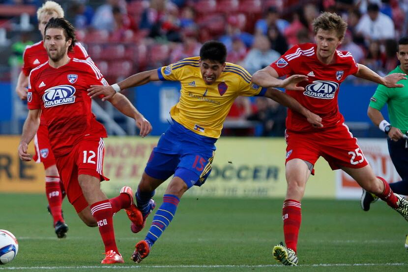 Rapids midfielder Juan Ramirez (15) looses his balance between FC Dallas midfielder Ryan...