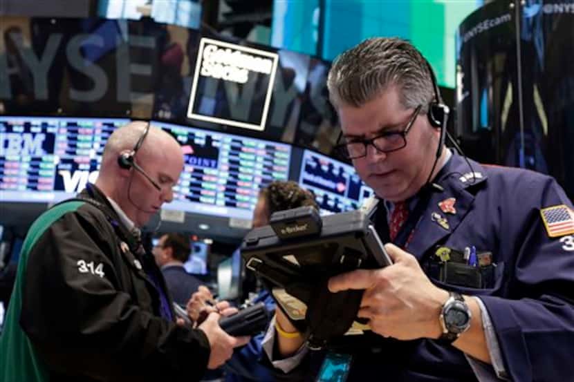 Traders Kevin Walsh, left, and John Panin work on the floor of the New York Stock Exchange...