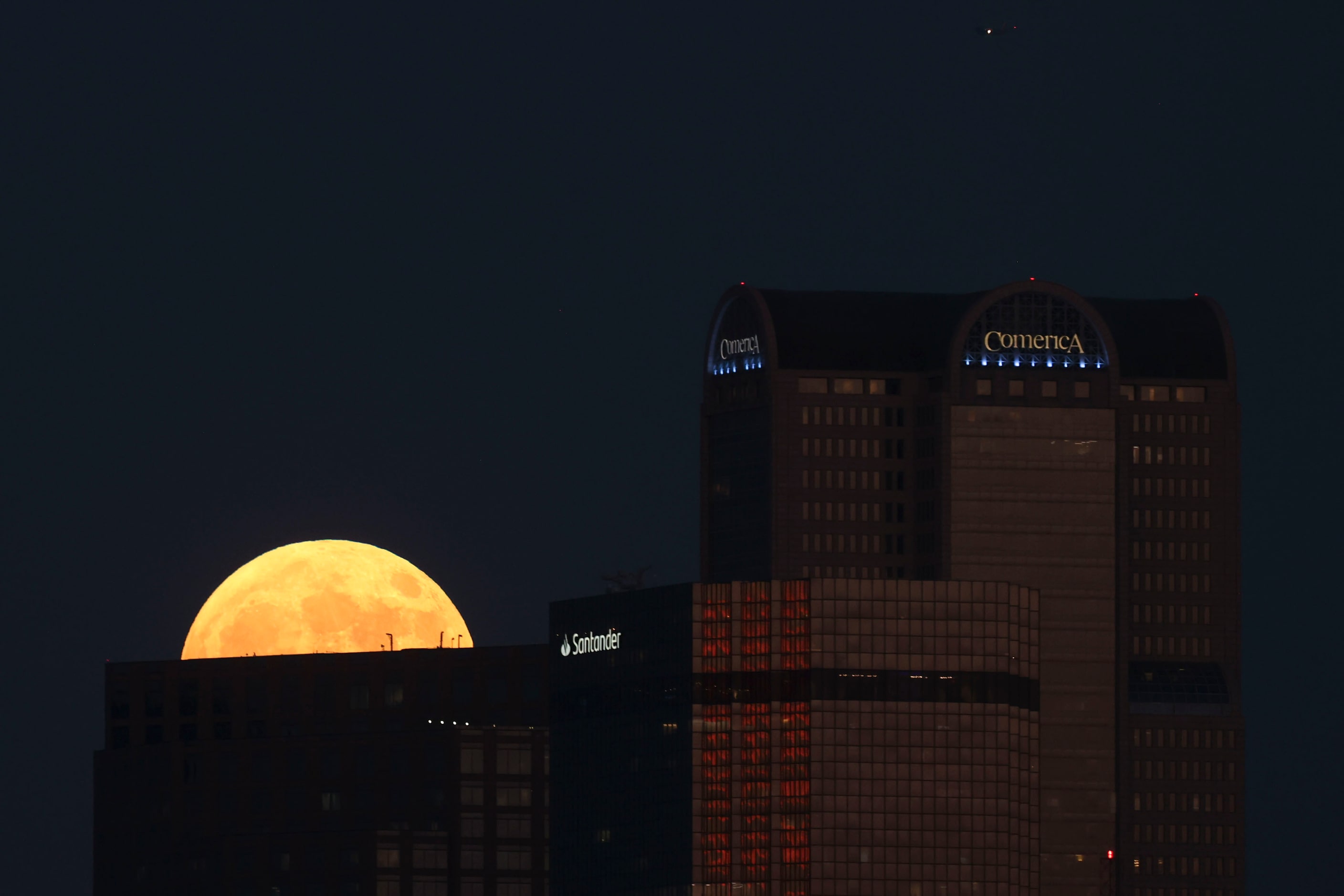 A full super harvest moon rises by Dallas’ Comerica bank tower, on Tuesday, Sept. 17, 2024. 