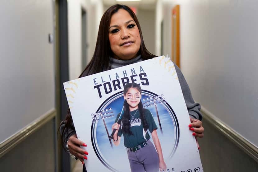 Sandra Torres, muestra un cartel con la foto de su hija Eliahna, una de los 19 niños y dos...