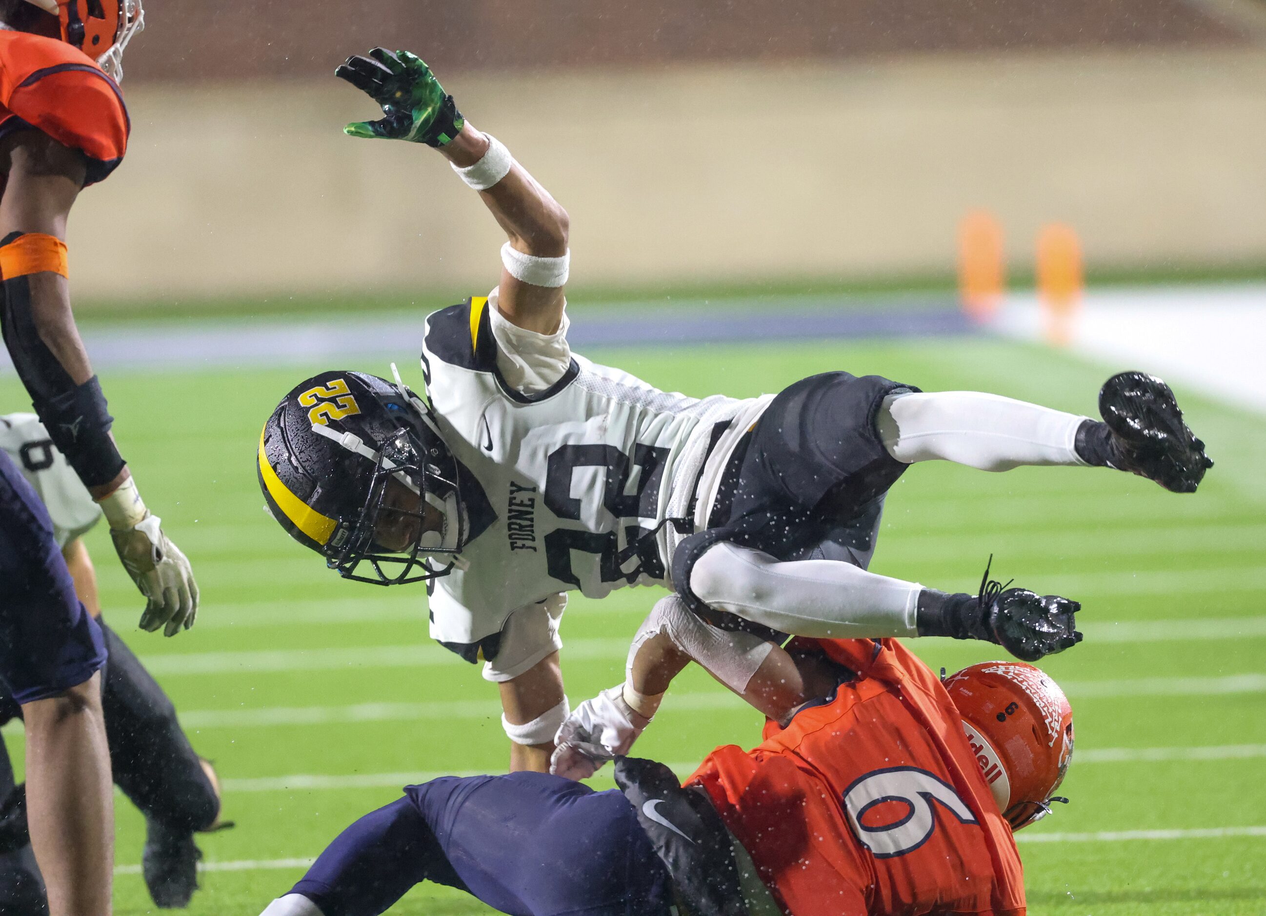 Forney defensive back Joshua Gatlin (22) falls over McKinney North quarterback Gavin...