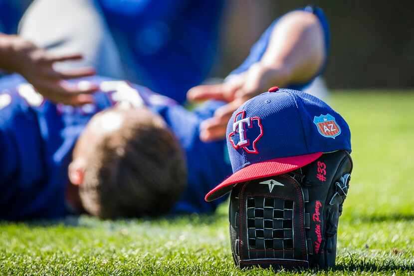 Texas Rangers pitchers stretch after a spring training workout at the team's training...