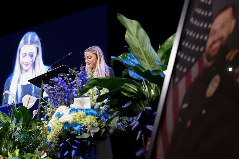 Aubrey Dawson becomes emotional as she speaks during the funeral service for her husband,...